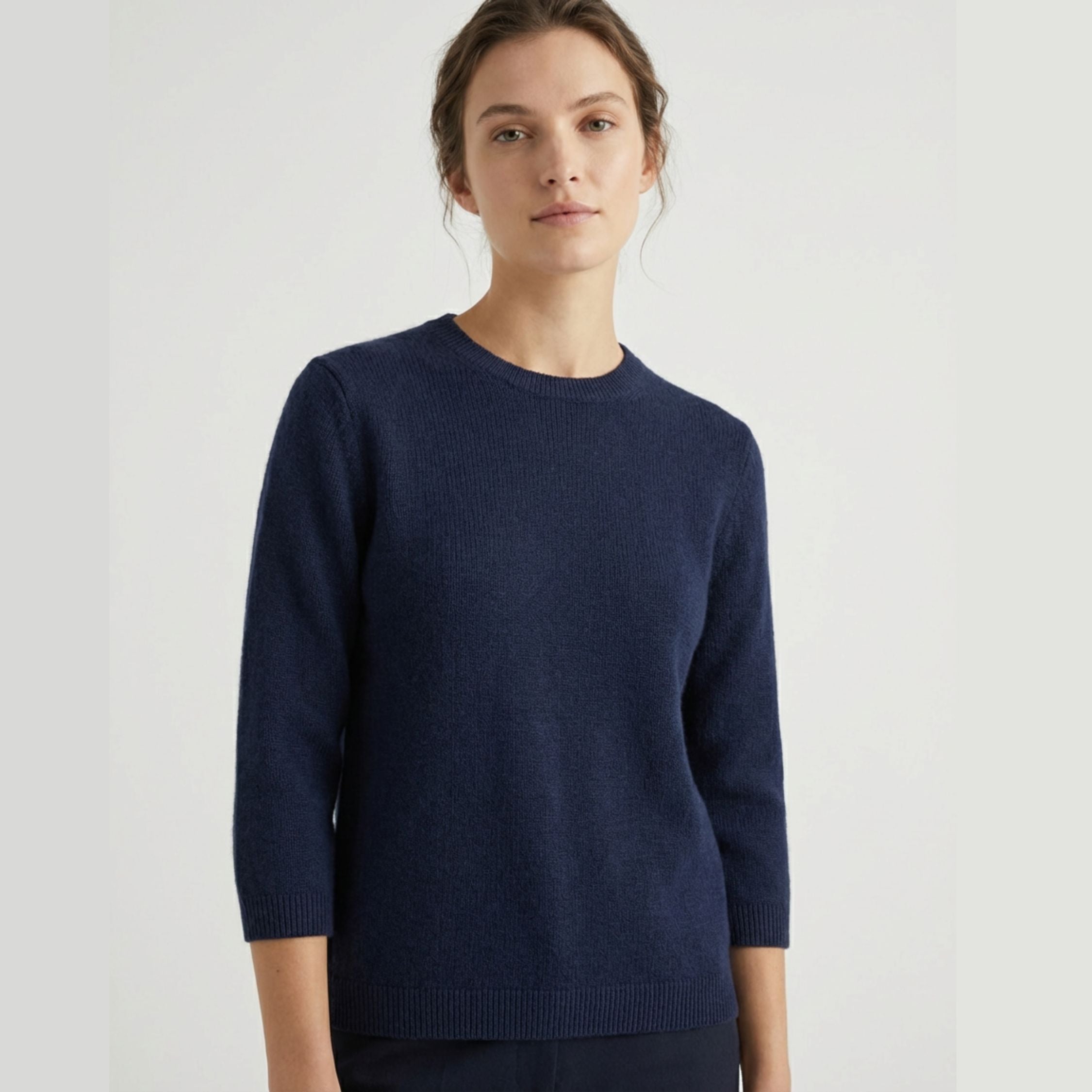 Female model wearing a navy blue, regular-fit 3 quarter sleeve sweater made of 100% cashmere pashmina, paired with navy blue trousers.