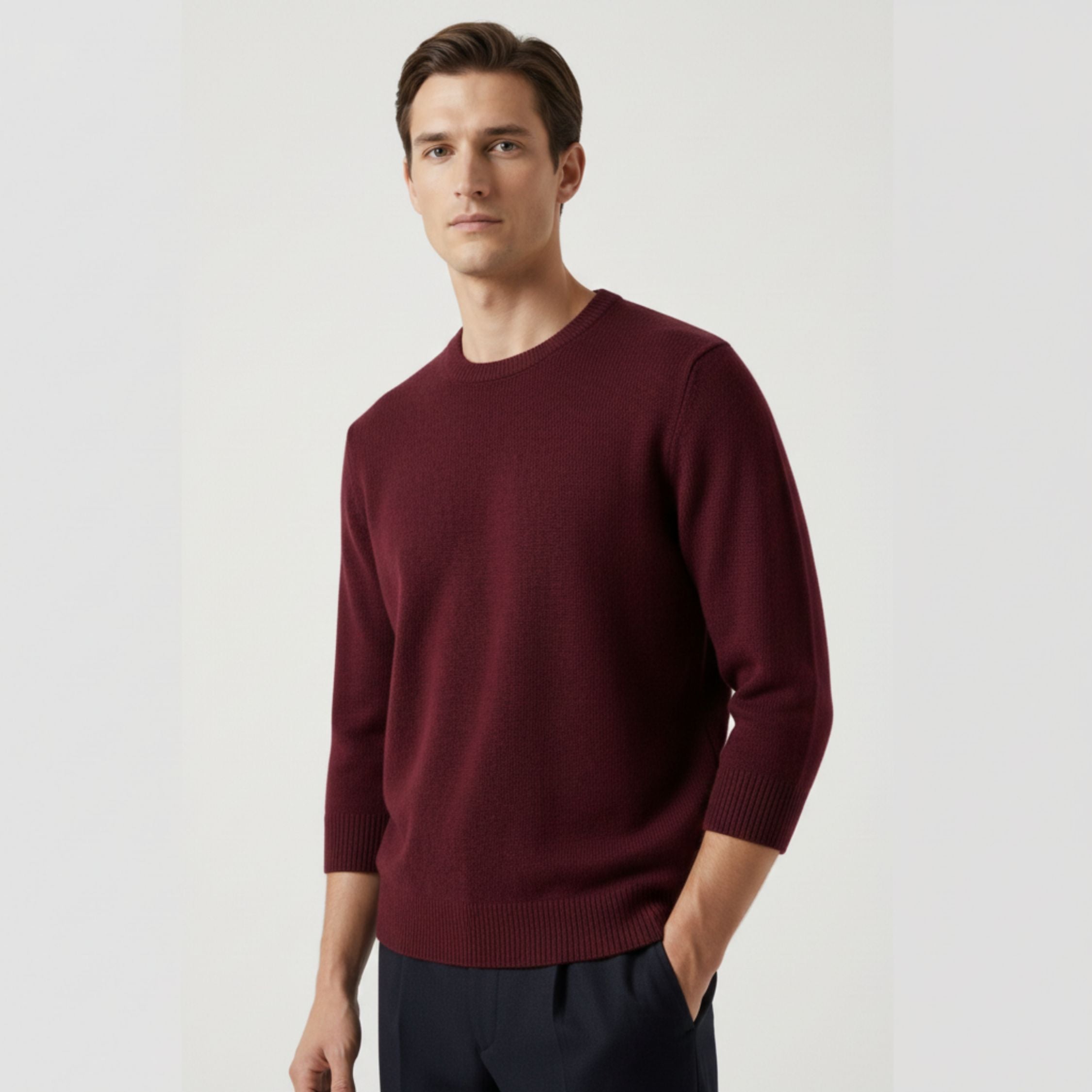 Male model wearing a maroon red, regular-fit 3 quarter sleeve sweater made of 100% cashmere pashmina, paired with black trousers.