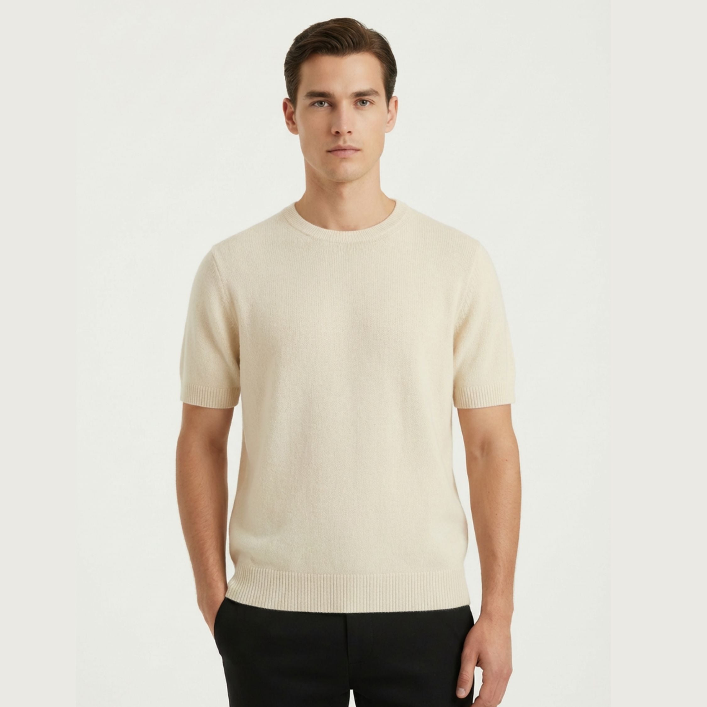 Male model wearing a Cream White regular-fit knitted T-shirt made of 100% cashmere pashmina, paired with Black trousers.