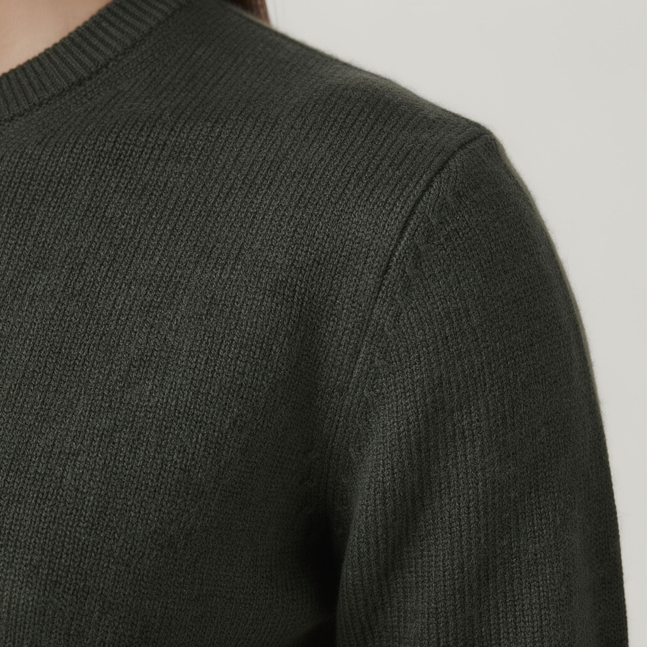 Dark gray ribbed 100% Cashmere sweater on a neutral background.