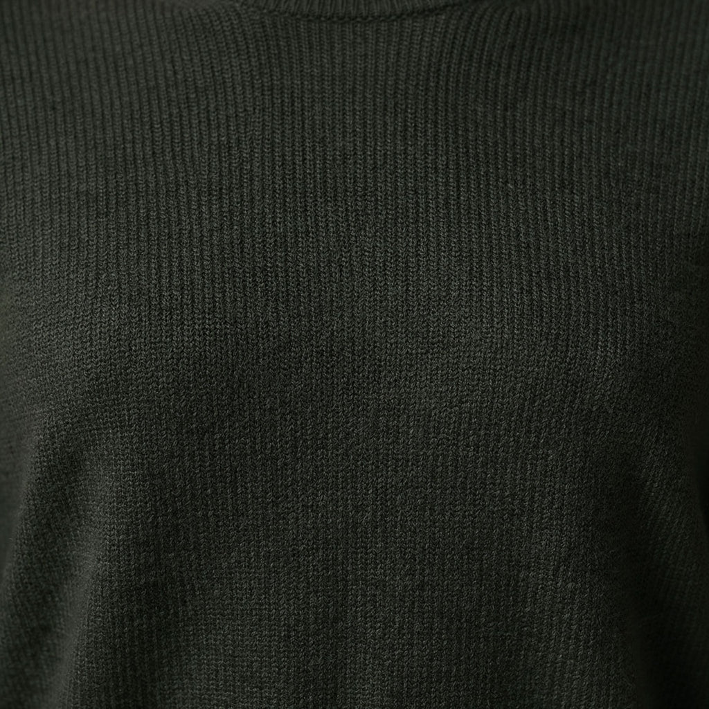 Close-up of a dark green ribbed knit 100% Cashmere sweater texture.