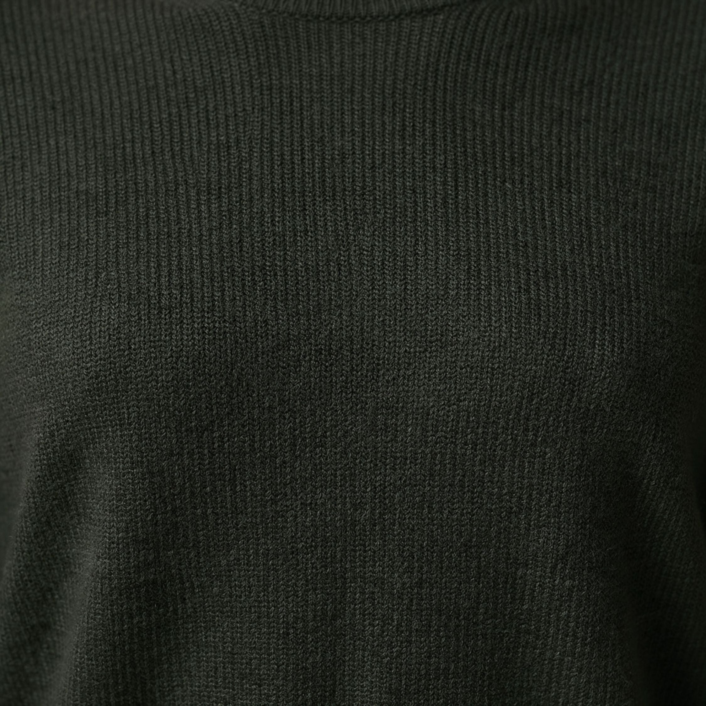 Close-up of a dark green ribbed knit 100% Cashmere sweater texture.