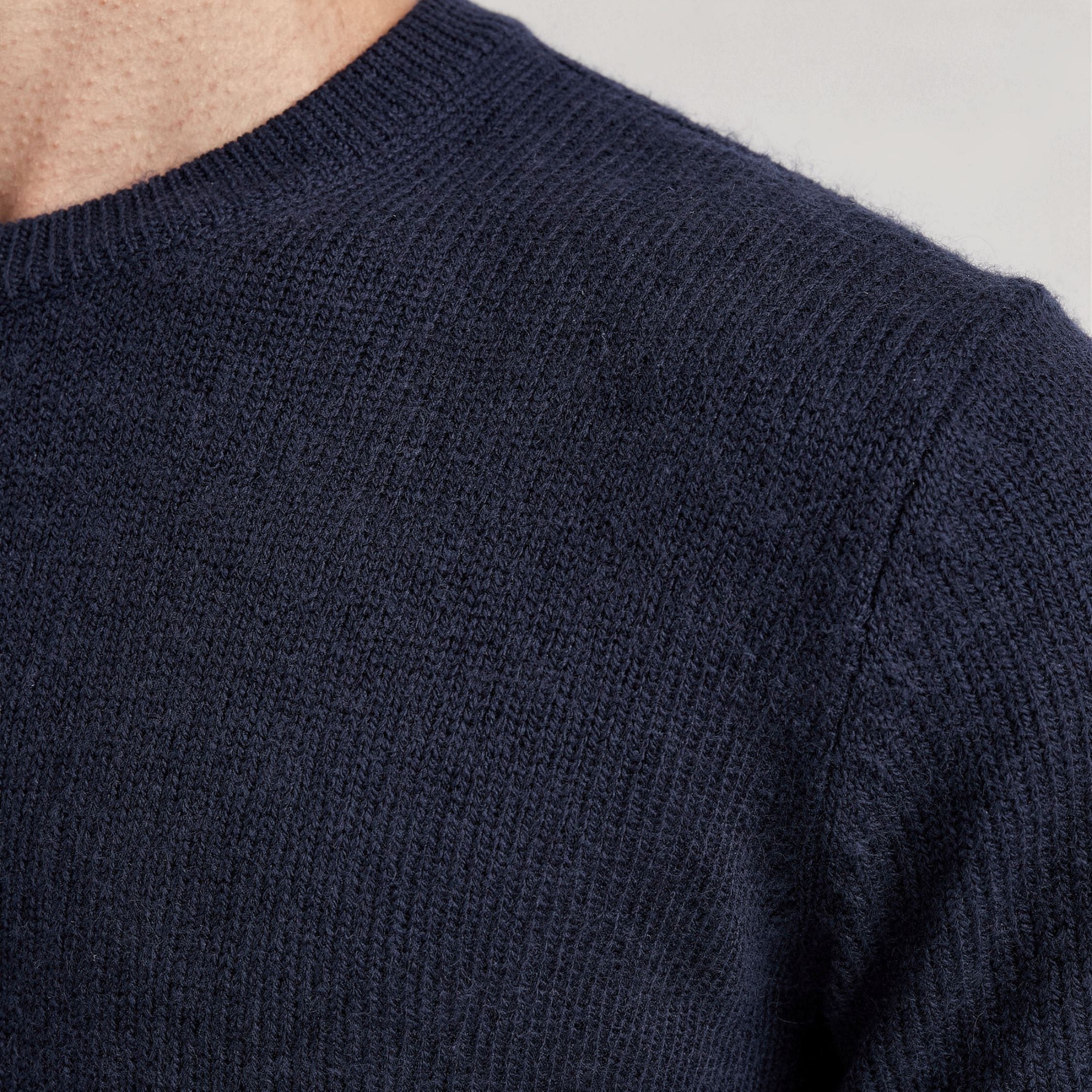 Close-up of a navy blue 100% Cashmere sweater with a textured pattern.