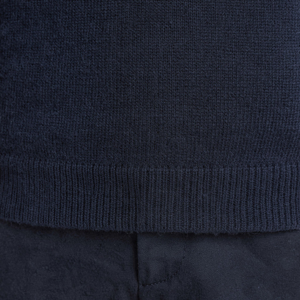Close-up of a dark blue 100% Cashmere sweater with a textured pattern.