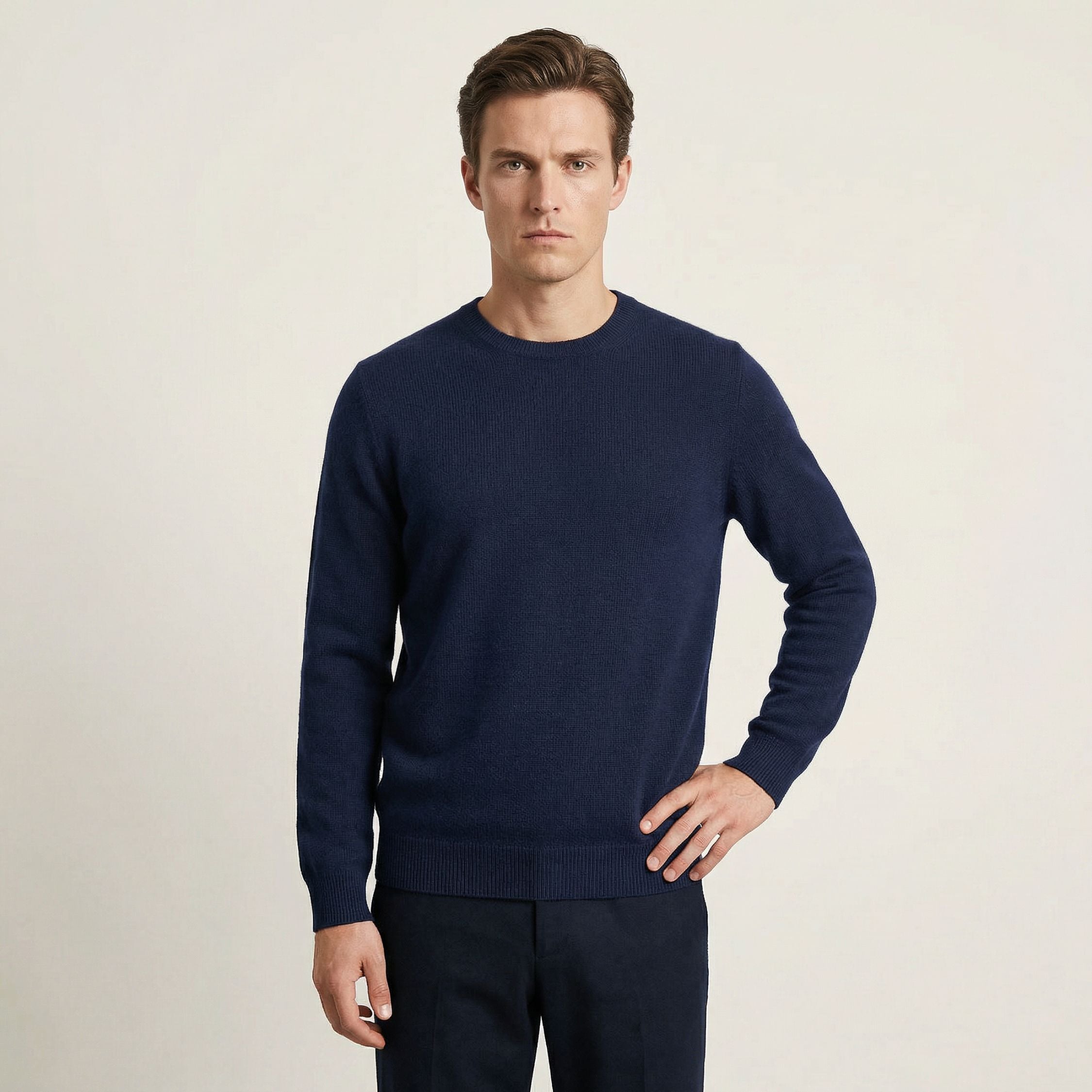 Man wearing a navy 100% Cashmere sweater against a light background.