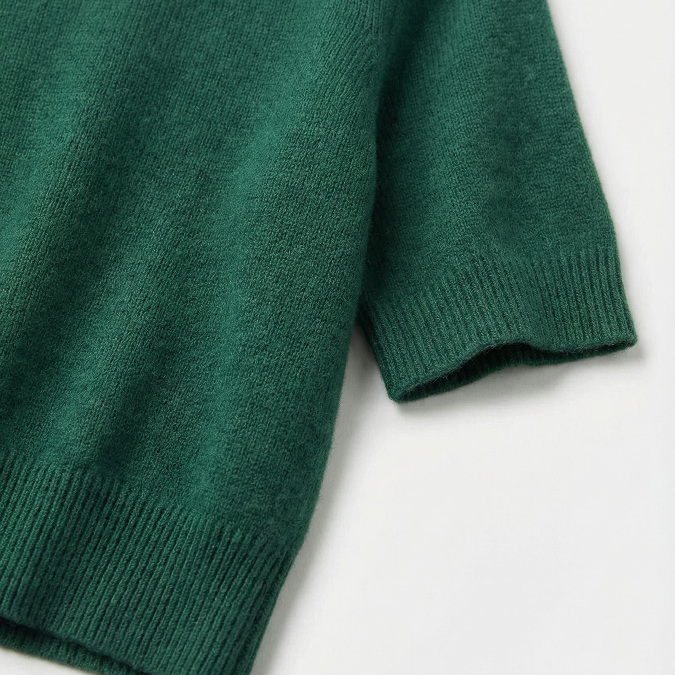 Close-up of an royal green 2-ply cashmere Crop top short sleeve, showcasing the fine 13-gauge single jersey stitch and a ribbed crewneck along the neckline, ribbed cuffs and hem.