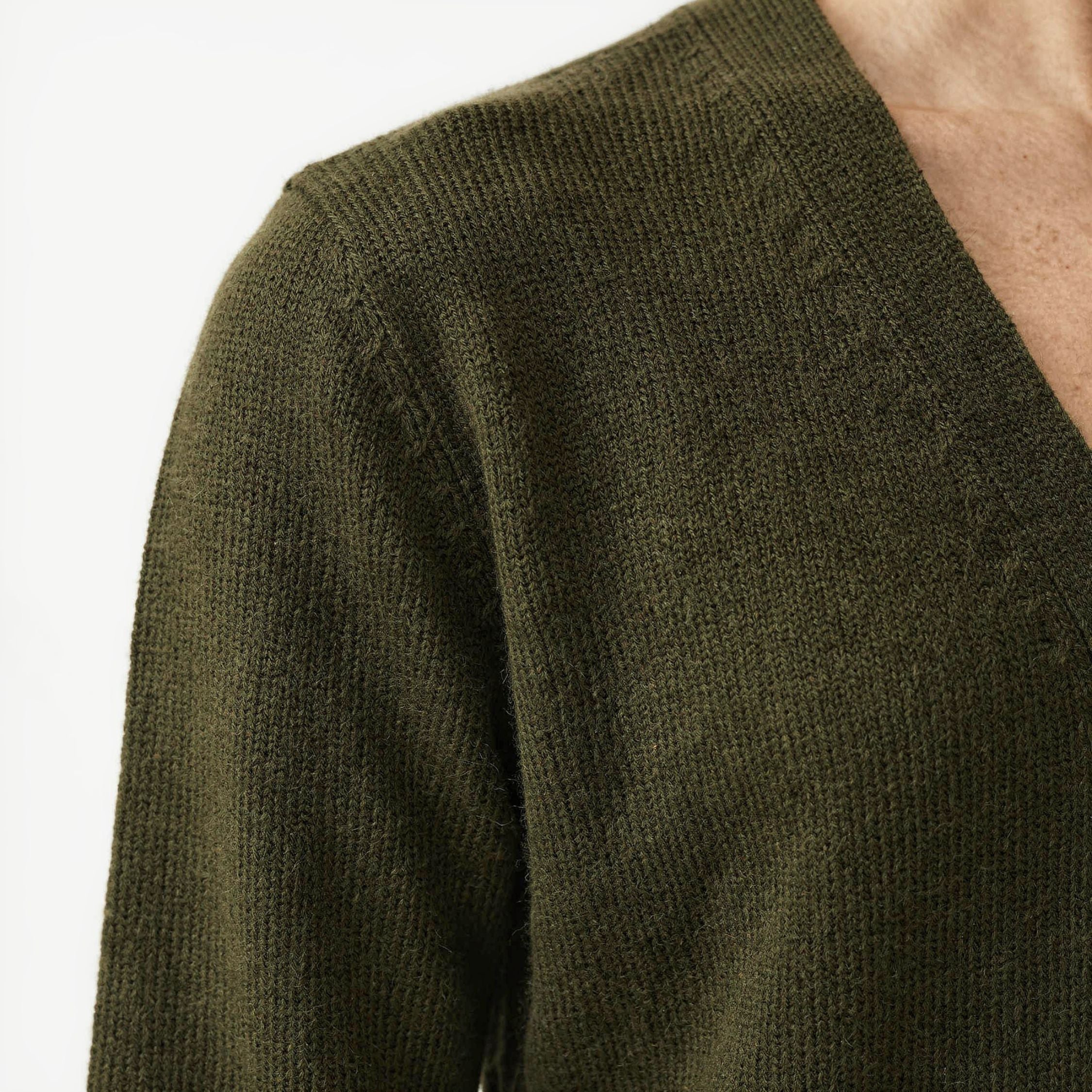 Close-up of a green 100% cashmere cardigan with a brand logo on a white background