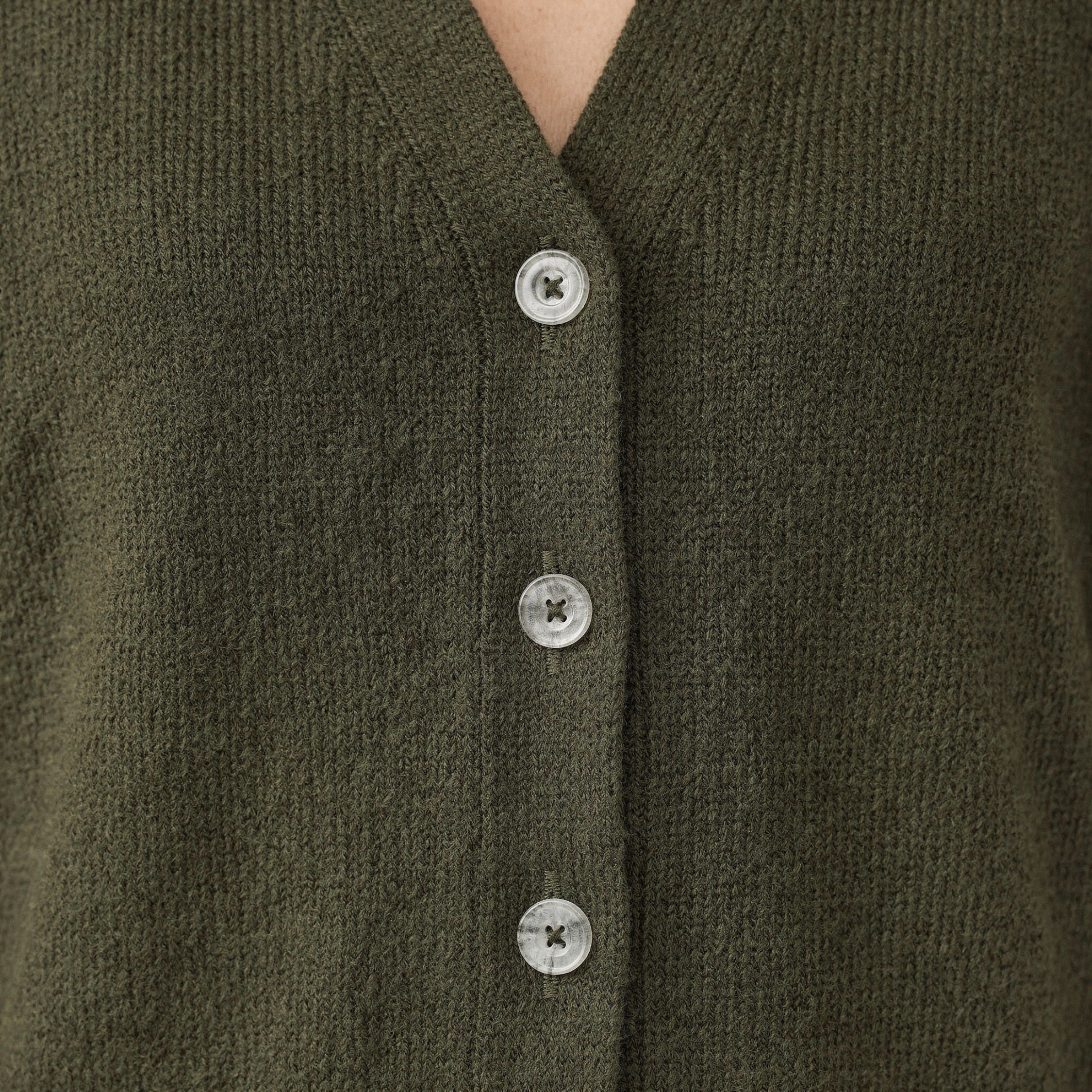 Close-up of a green 100% cashmere cardigan with button details