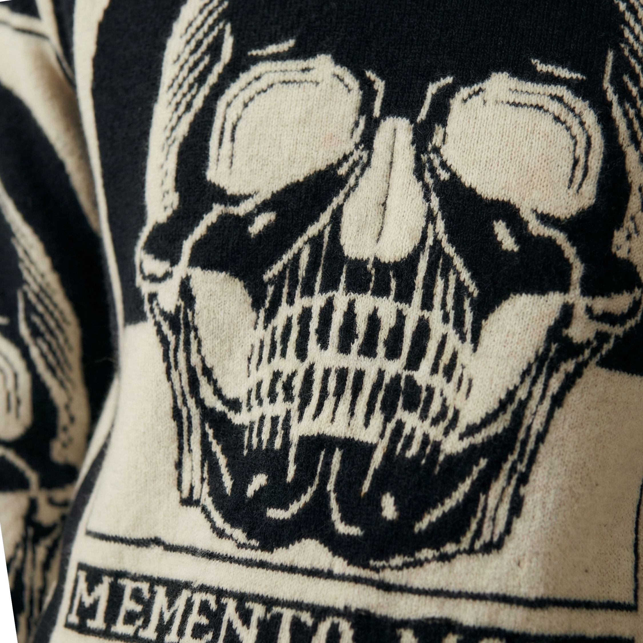 Close-up of a black and white skull design with 'Memento' text on 100% cashmere.