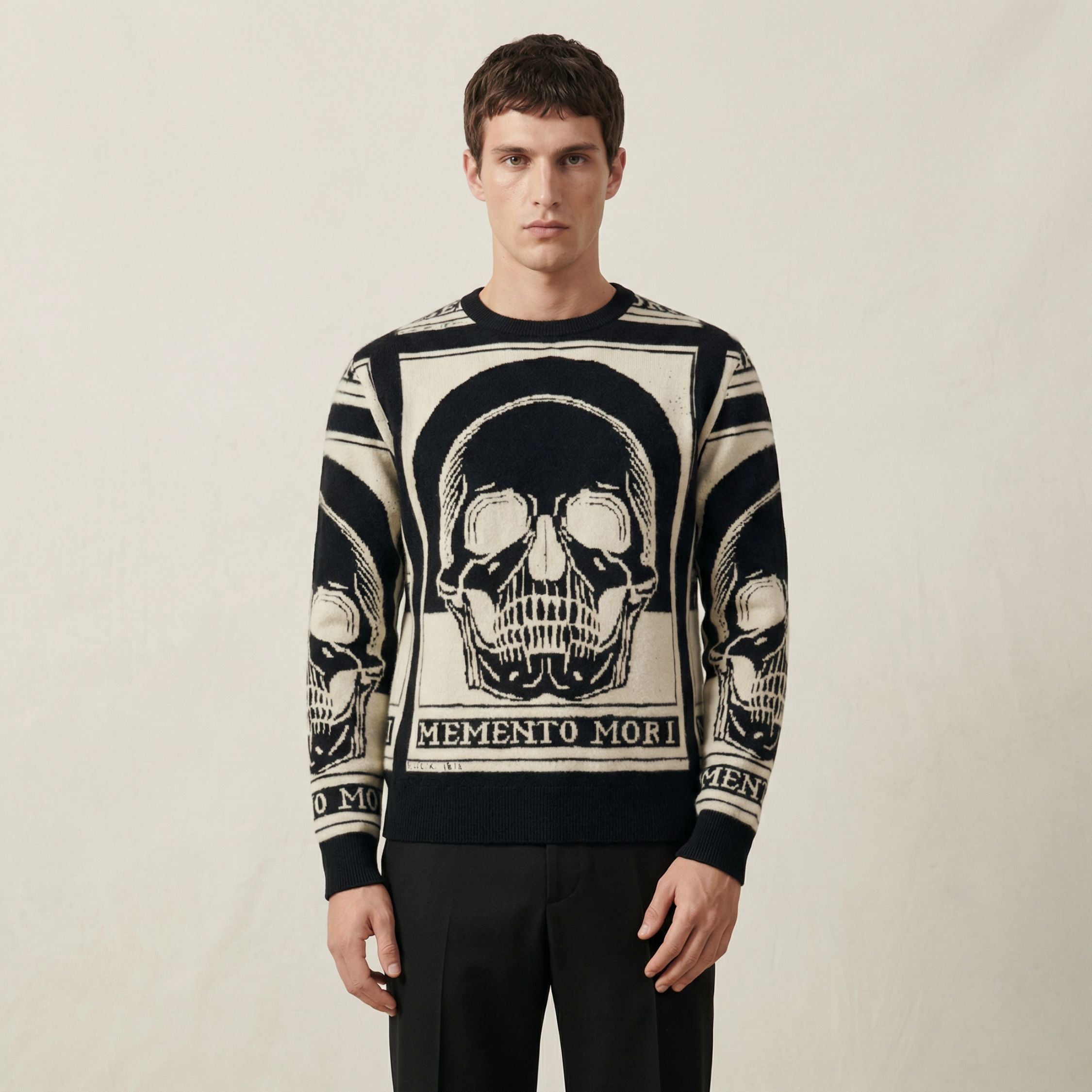 Man wearing a 100% cashmere sweater with skull design and 'Memento Mori' text on a plain background