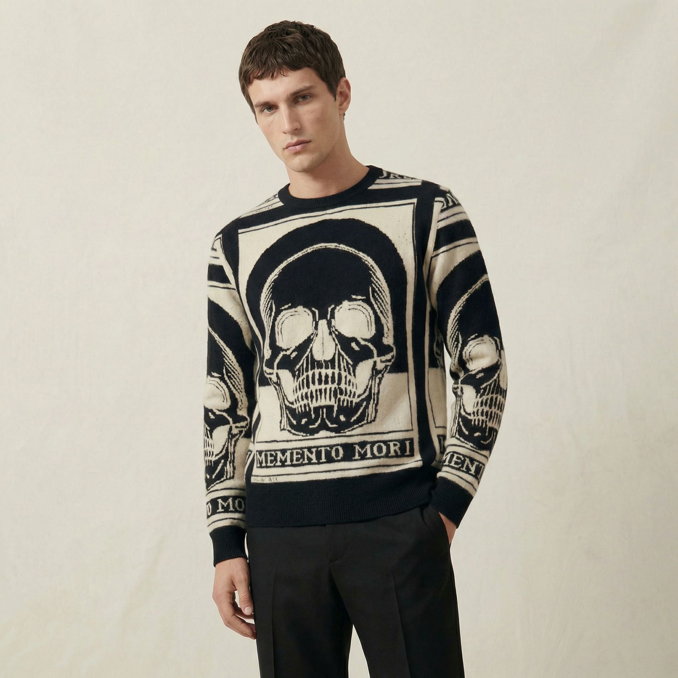 Man wearing a 100% cashmere sweater with skull design and 'Memento Mori' text on a plain background