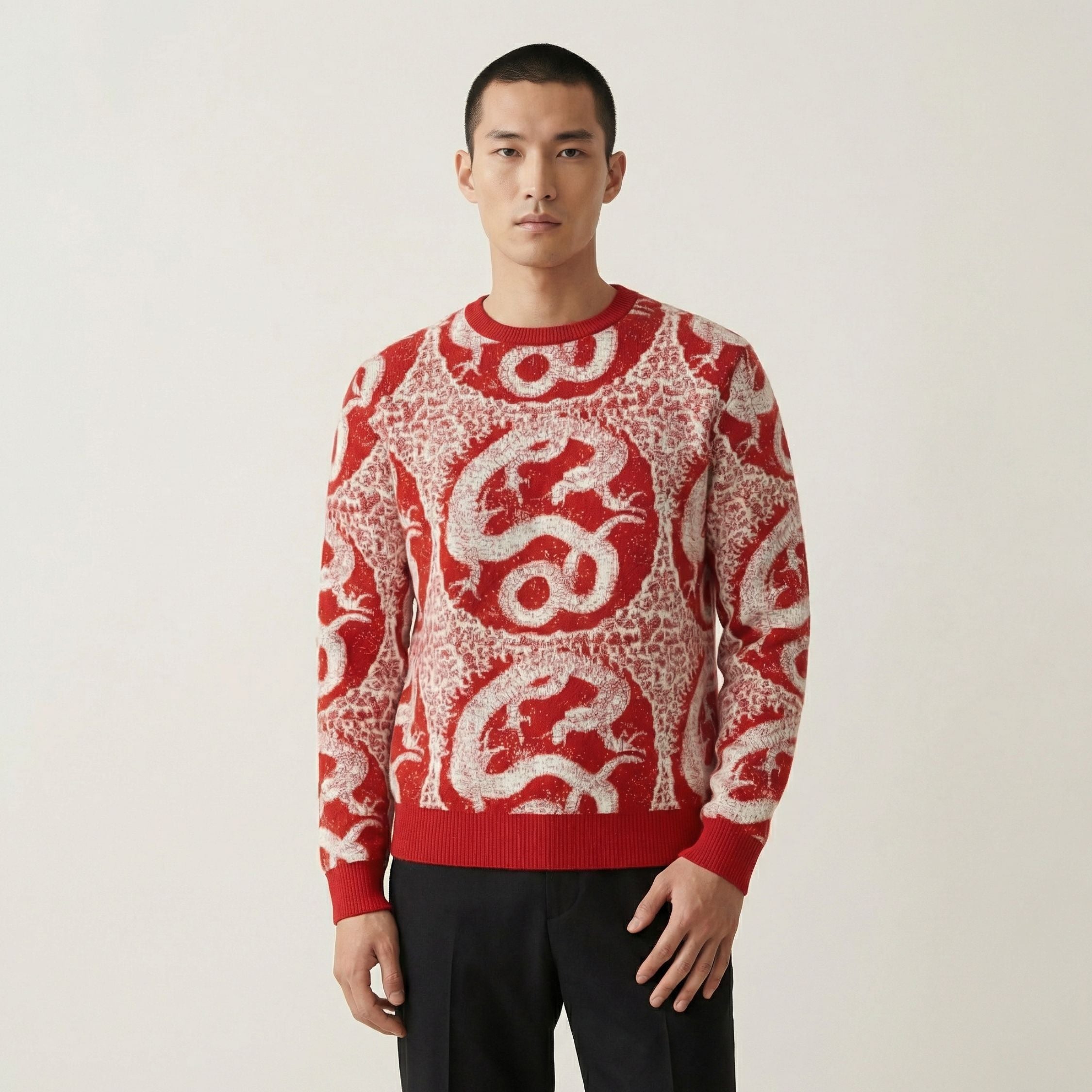 Man wearing a 100% cashmere red sweater with white patterns on a plain background.