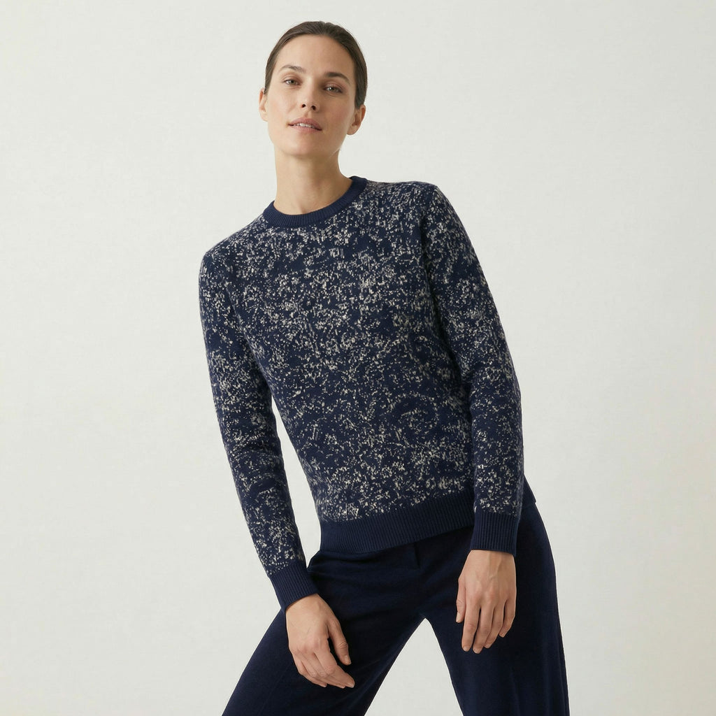 Woman wearing a 100% cashmere navy blue floral-patterned sweater on a white background