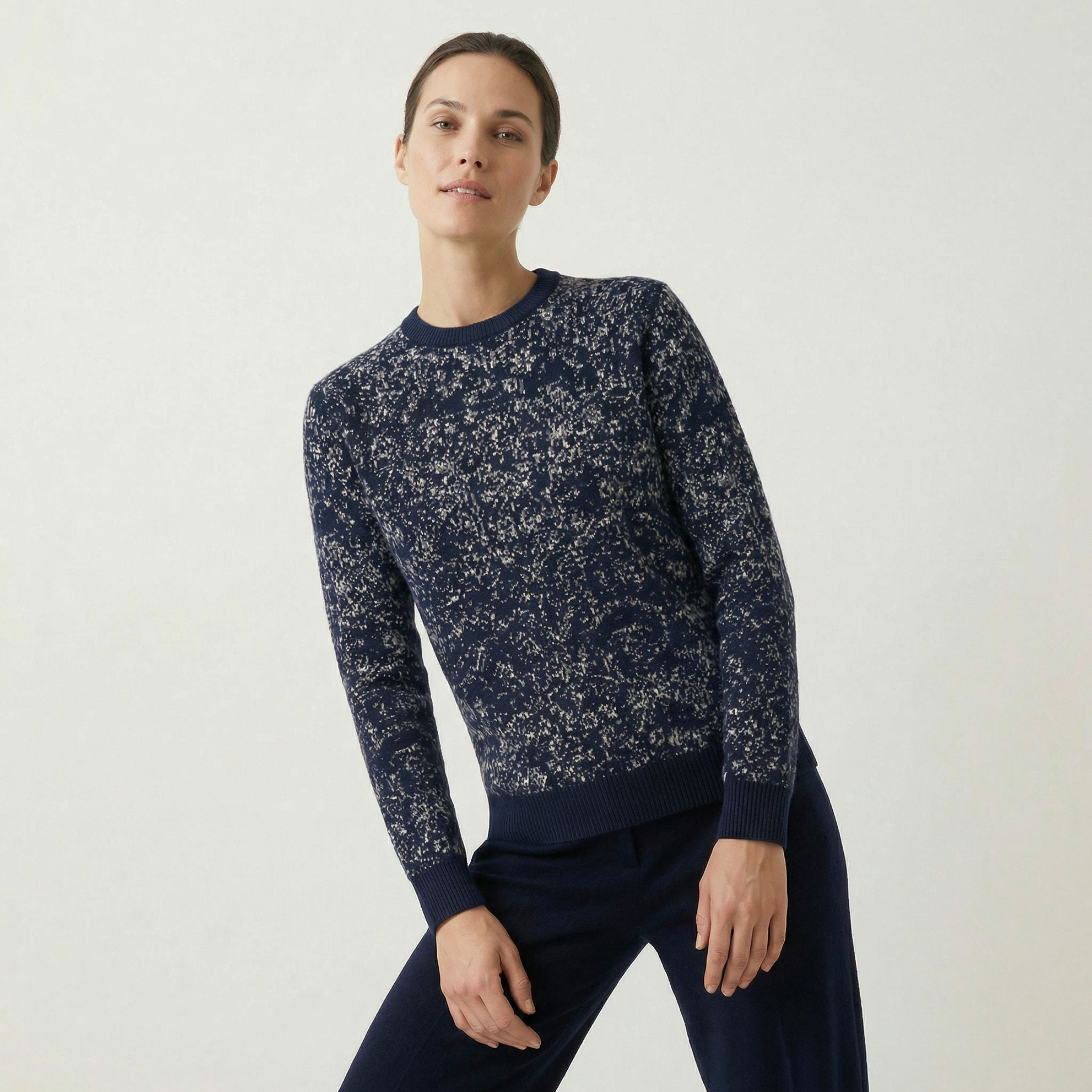 Woman wearing a 100% cashmere navy blue floral-patterned sweater on a white background