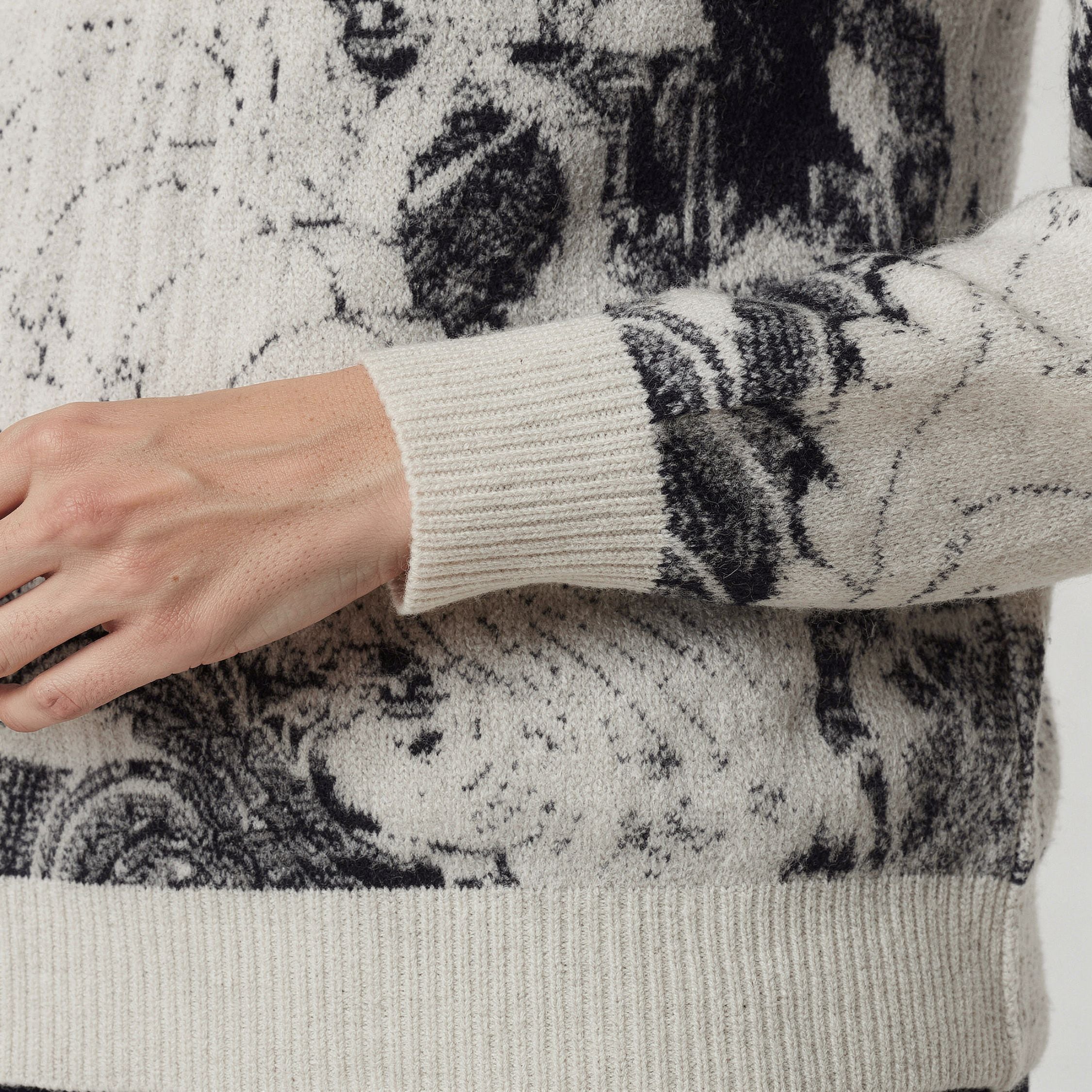 Close-up of a person wearing a 100% cashmere patterned sweater with a focus on the sleeve.