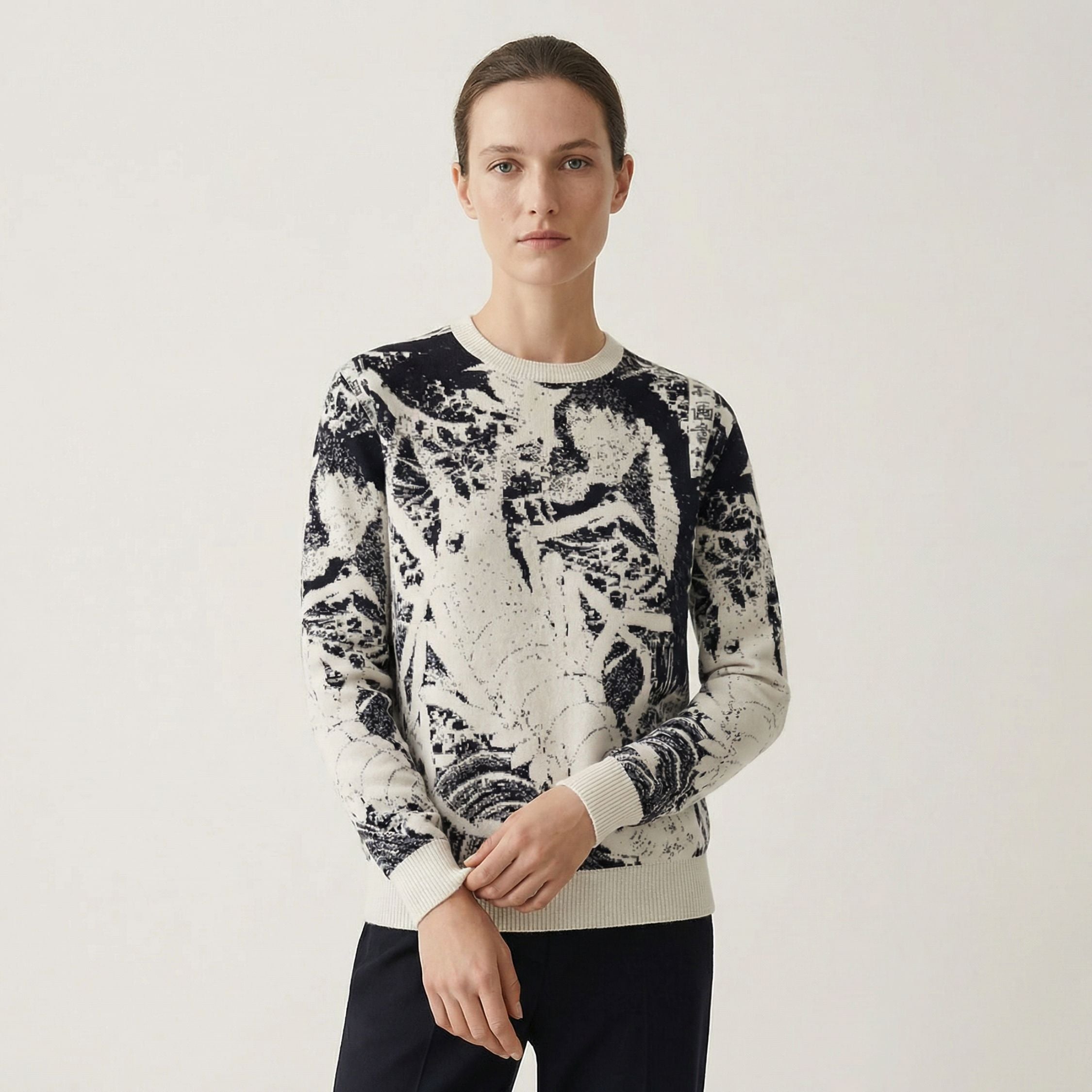 Person wearing a patterned 100% cashmere sweater on a plain background