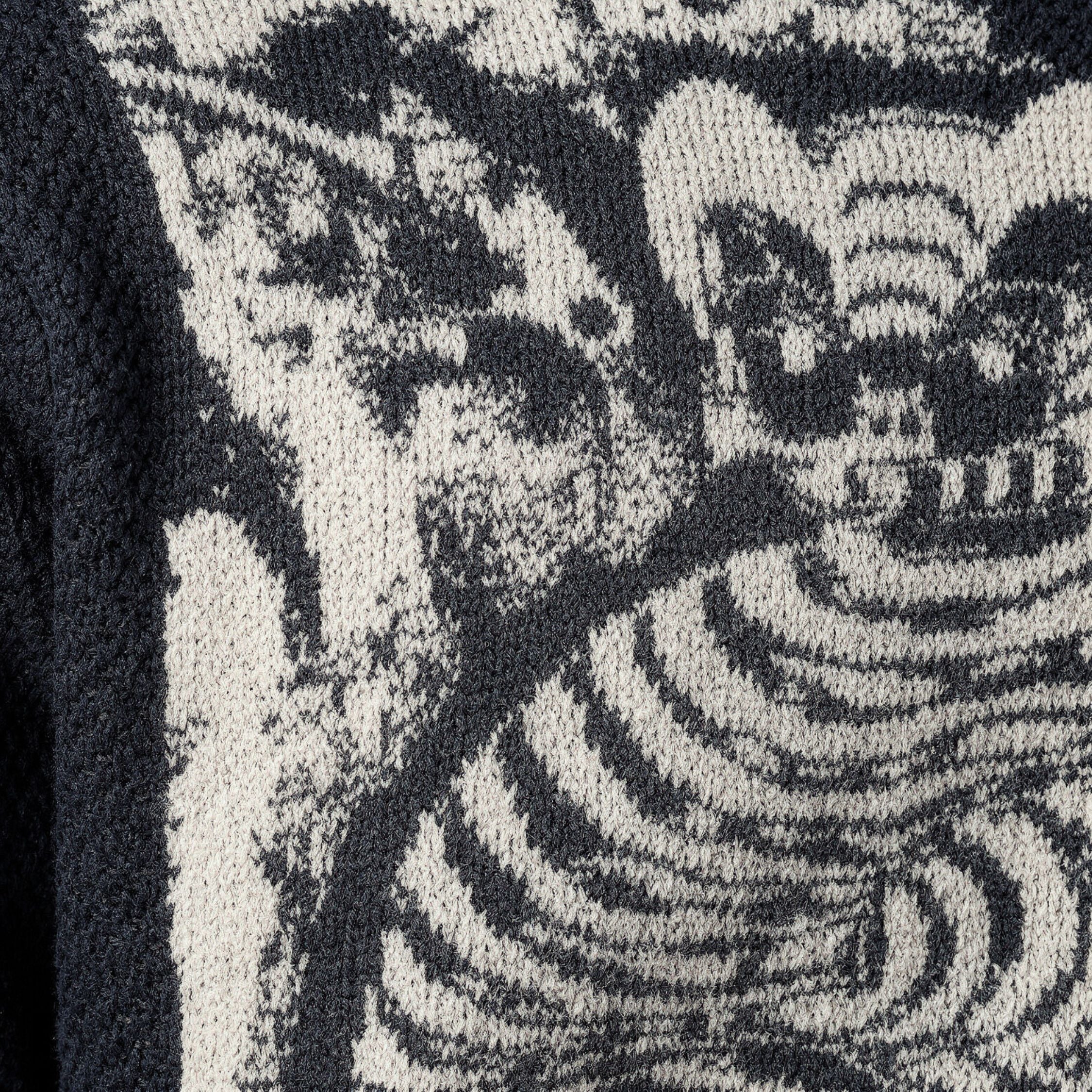 Close-up of a textured cashmere with a pattern resembling a tiger and abstract shapes.