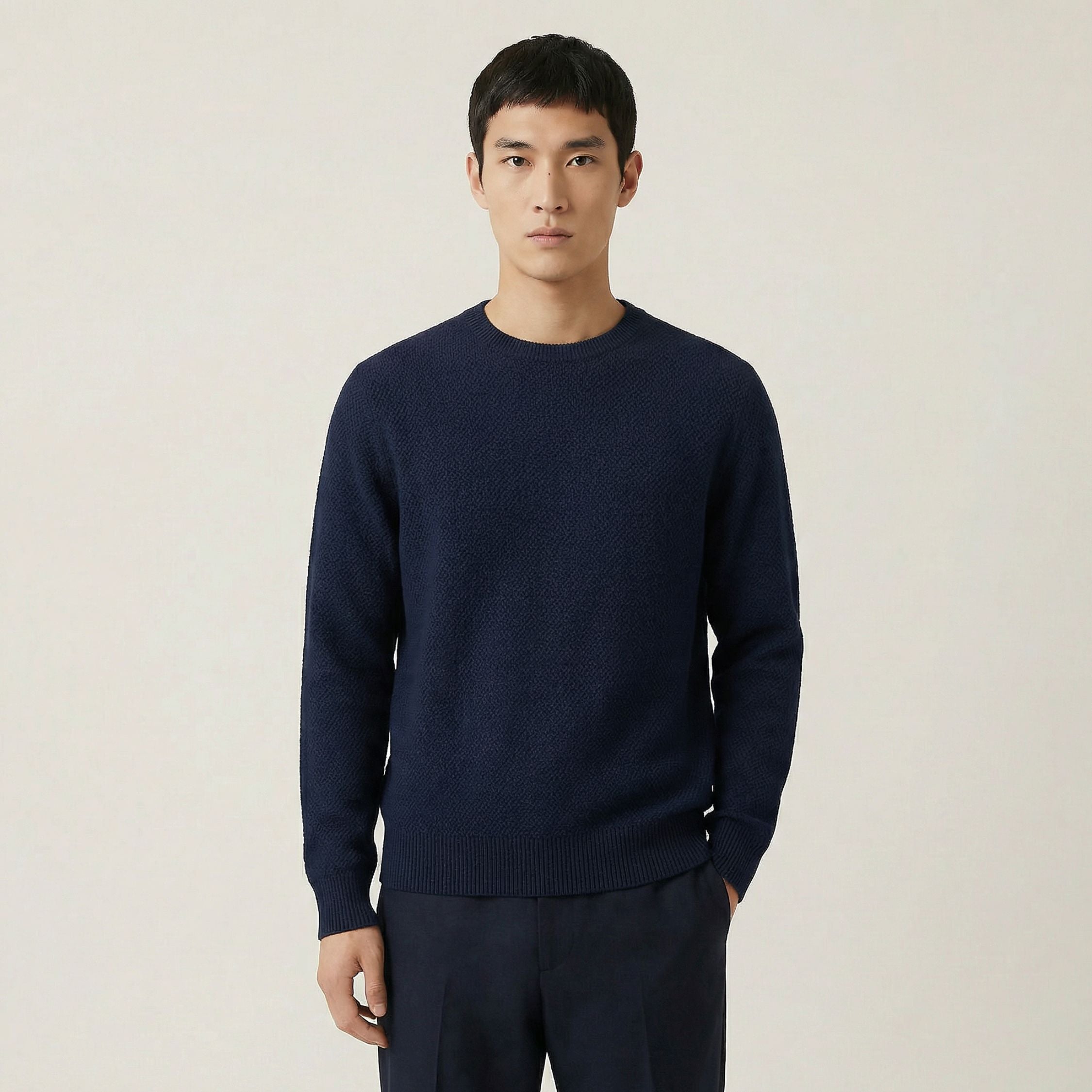 Man wearing a 100% cashmere navy sweater against a plain background