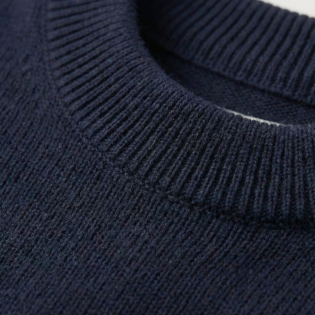 Close-up of an Navy Blue 2-ply cashmere relaxed arm Sweater, showcasing the fine 13-gauge single jersey stitch and a ribbed crewneck along the neckline.
