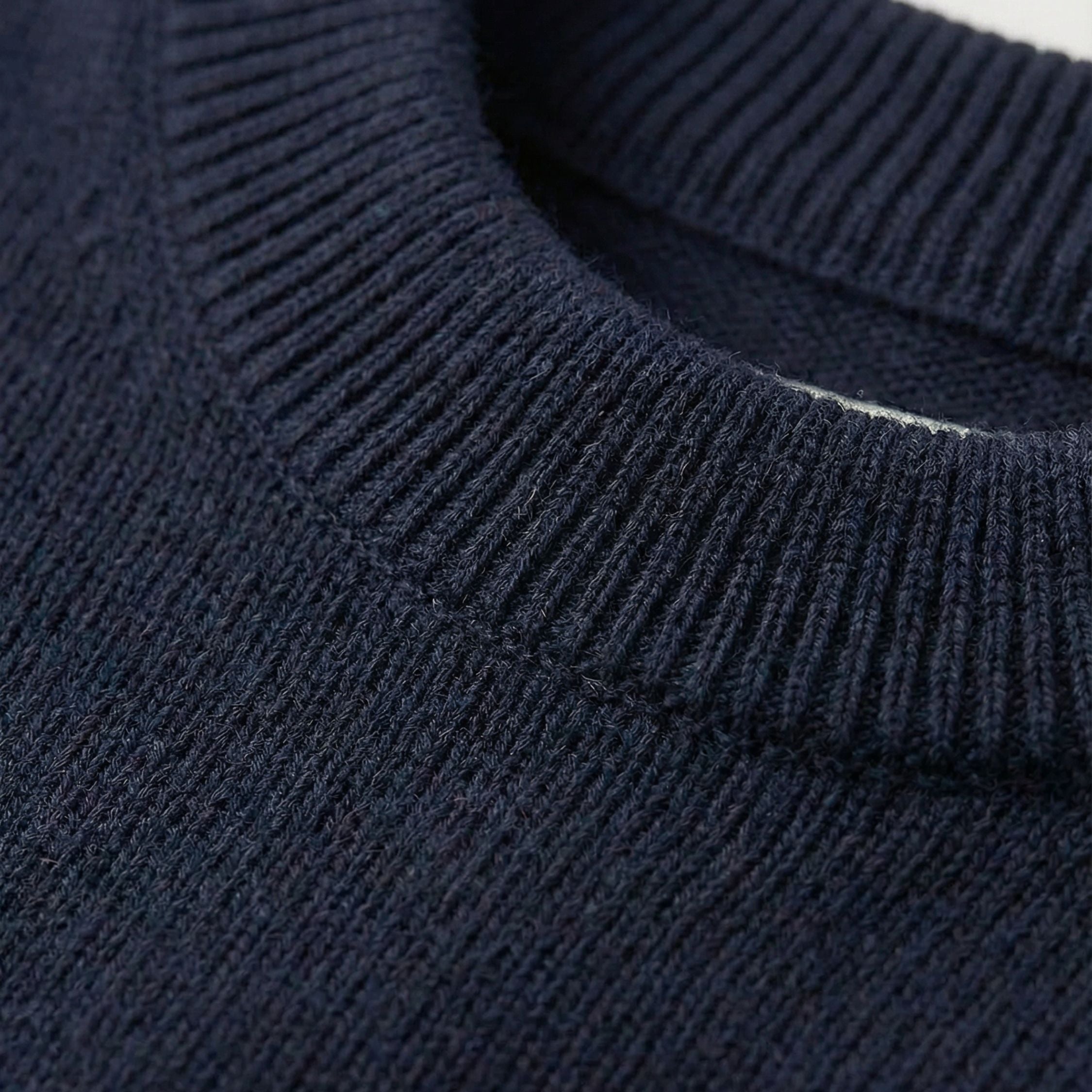 Close-up of an Navy Blue 2-ply cashmere relaxed arm Sweater, showcasing the fine 13-gauge single jersey stitch and a ribbed crewneck along the neckline.