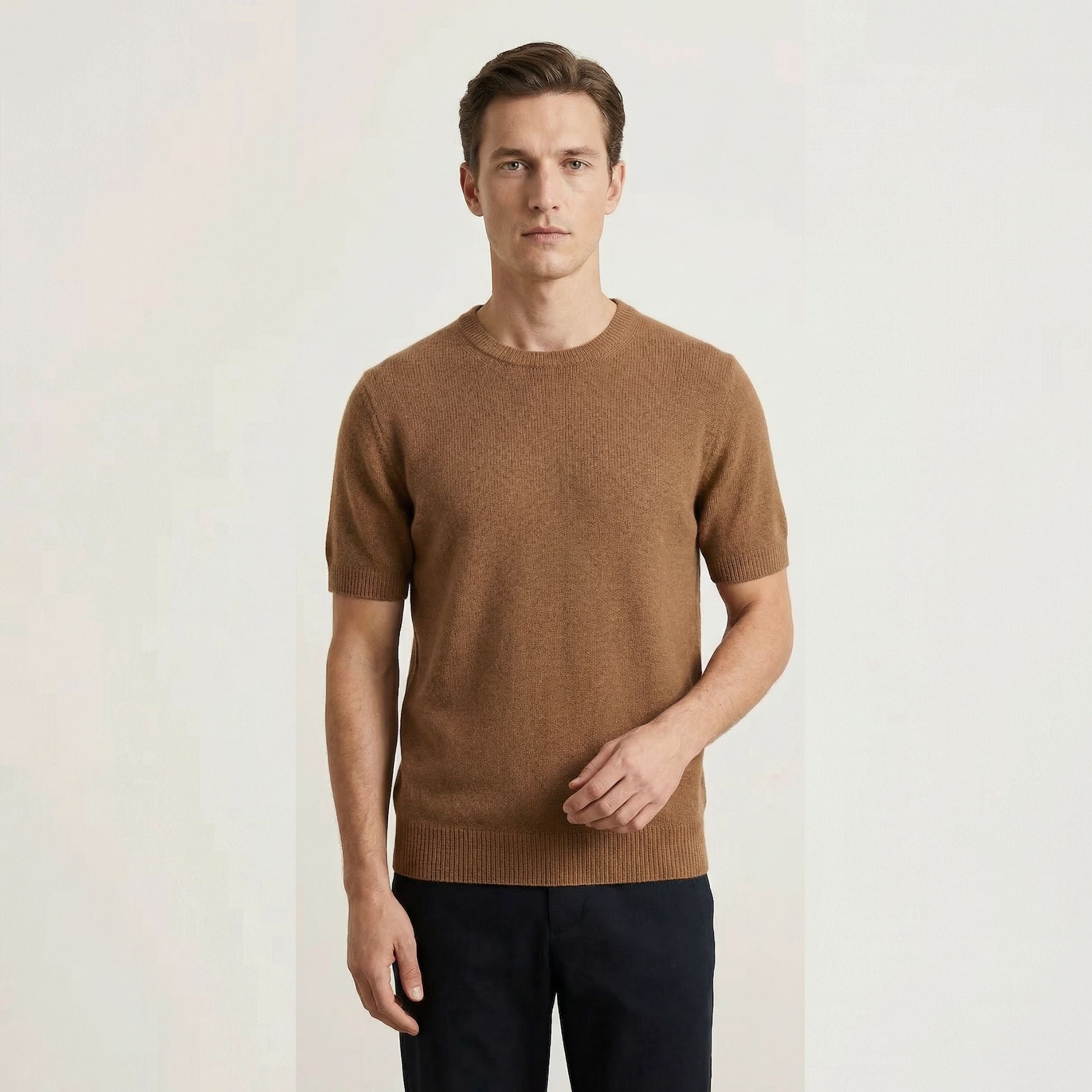 Man wearing a brown 100% cashmere sweater against a plain background.